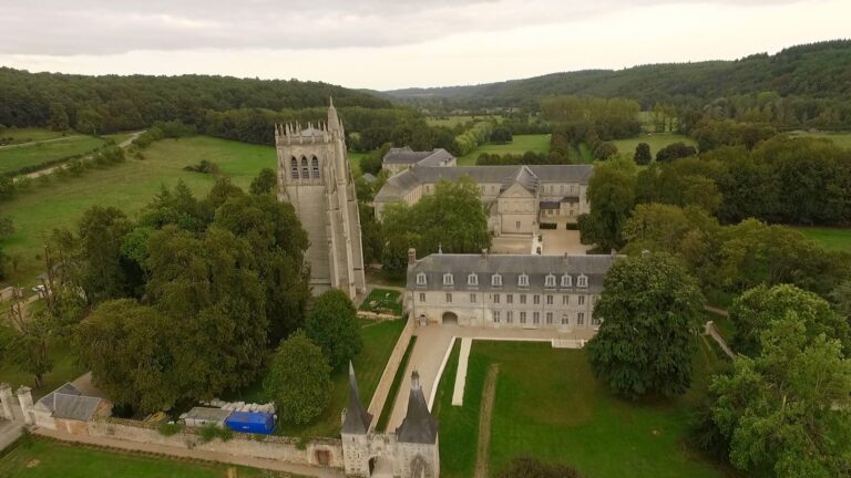 Vue aérienne de l'abbaye du Bec-Hellouin entourée de verdure en Normandie