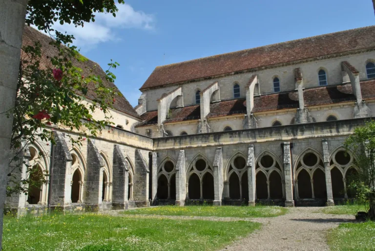 Vue panoramique sur l'abbaye de Noirlac entourée de verdure en Val de Loire