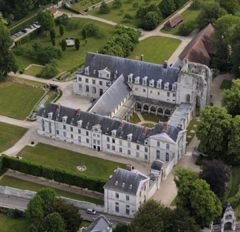 Vue majestueuse de l'Abbaye de Saint-Wandrille entourée de verdure, un lieu emblématique d'histoire et de spiritualité.