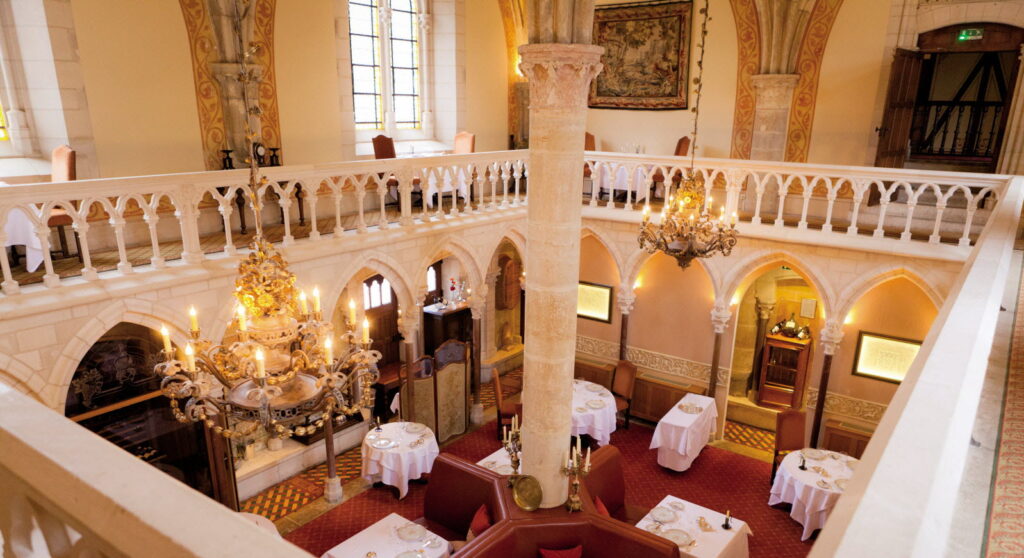 Salle élégante du restaurant 1131 à l'Abbaye de la Bussière avec une table dressée pour un repas gastronomique.