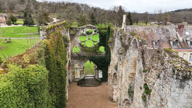 Vue majestueuse de l'Abbaye des Vaux de Cernay sous un ciel bleu, un lieu chargé d'histoire et de charme