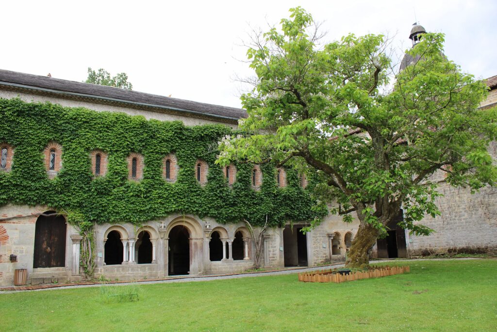 Vue panoramique de l'Abbaye de l'Escaladieu entourée de verdure, illustrant son architecture cistercienne