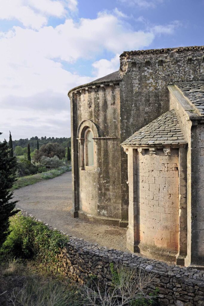 Vue pittoresque de l'Abbaye de Fontcaude entourée de nature, un joyau du patrimoine médiéval héraultais.