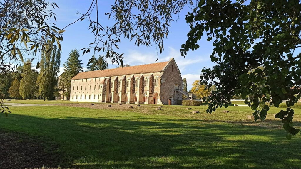 Vue panoramique de l'Abbaye Notre-Dame de Cîteaux entourée de verdure, un lieu chargé d'histoire en Bourgogne