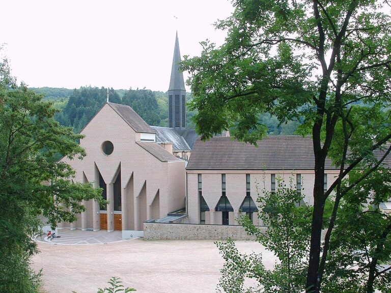 Vue panoramique de l'abbaye Sainte-Marie de la Pierre-qui-Vire entourée de verdure